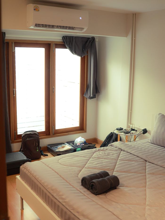 A cozy and modern bedroom interior in Bangkok with natural light and minimalistic decor.