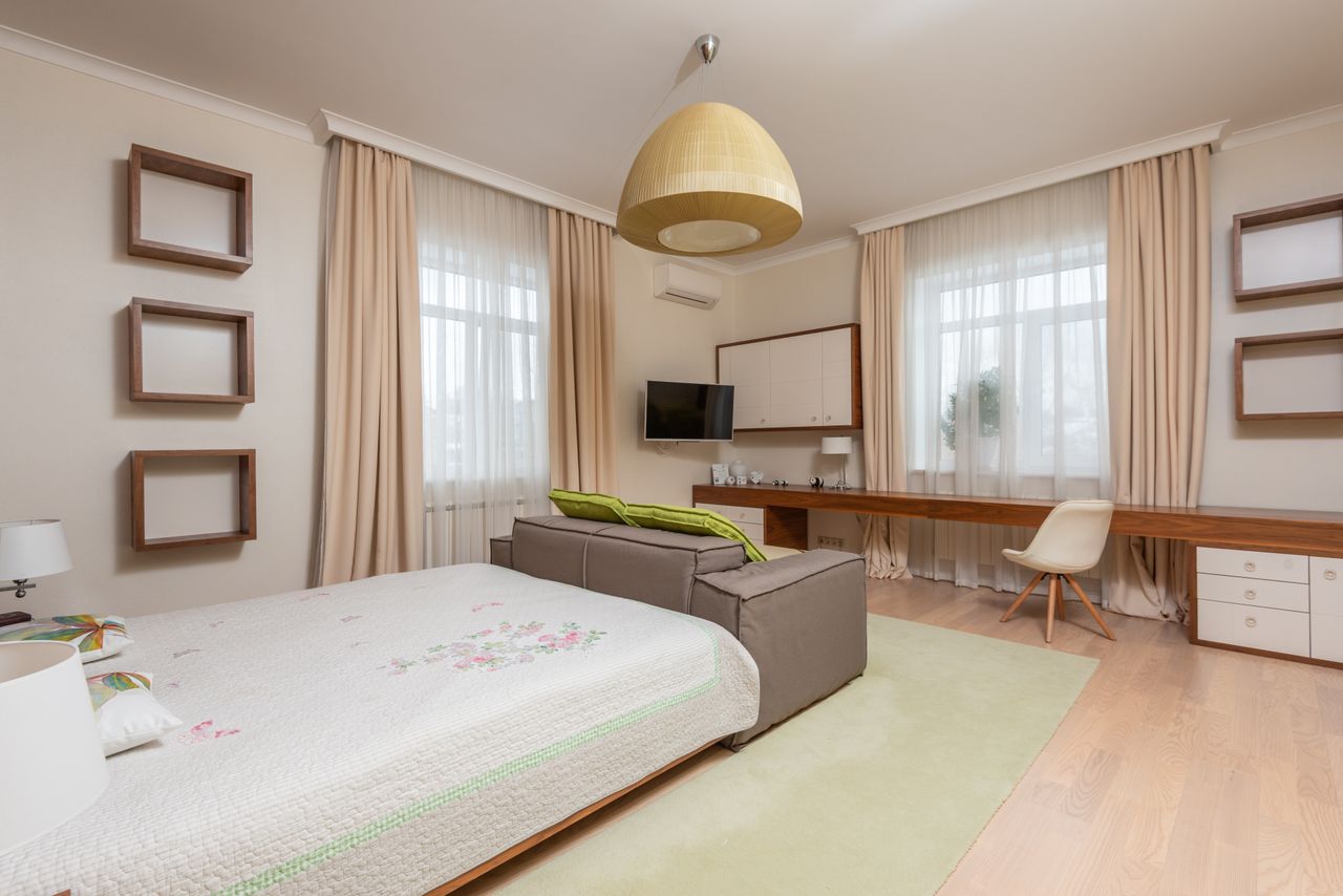 Interior of modern apartment with beige curtains and brown wooden table with white chair